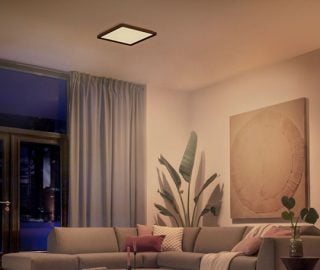 Una plafoniera quadrata Philips Hue illumina un soggiorno con una luce bianca e soffusa.