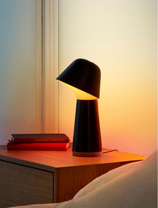 따뜻한 백색광을 내뿜는 Philips Hue Iris 테이블 램프. 