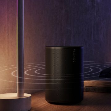 Een slimme Sonos luidspreker op een nachtkastje, gesynchroniseerd met Philips Hue lampen