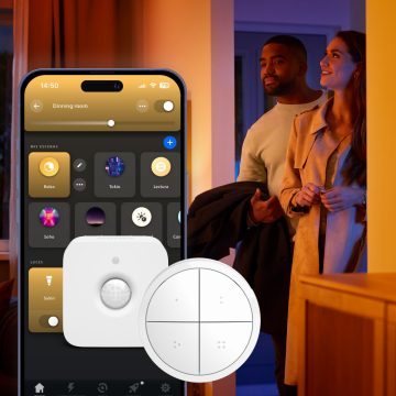 Couple in doorway with mobile phone, motion sensor, and smart switch overlay