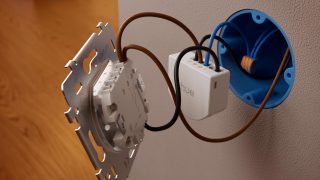 Een bedrade Hue aan/uit schakelaarmodule wordt geïnstalleerd bij een wandschakelaar om slimme bediening mogelijk te maken voor traditionele lampen. 