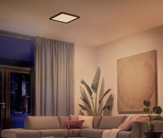 Kwadratowa lampa sufitowa Philips Hue rozświetlająca salon miękkim, białym światłem.