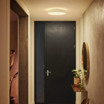 Okrągła lampa sufitowa ustawiona na jasne białe światło w korytarzu