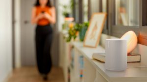 En man dansar till musik i sitt sovrum med Philips Hue-lampor och en smart högtalare från Sonos.